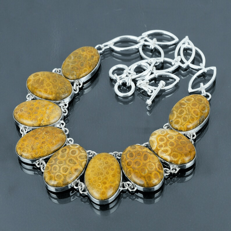Necklace with yellow stone pendants and silver chain on a dark background