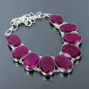 Necklace with pink gemstones and silver chain on a dark background