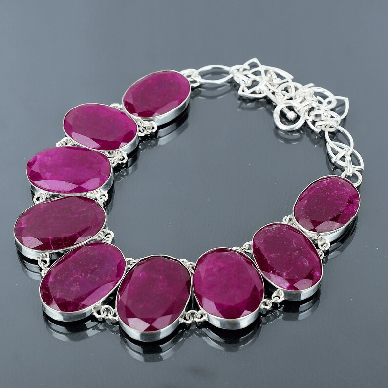 Silver bracelet with pink gemstones on a dark background