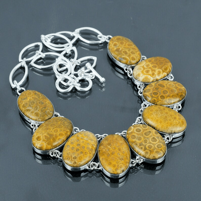 Bracelet with yellow stone beads and silver chain on a dark background