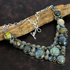 Necklace with Labradorite stones on a dark surface with wood
