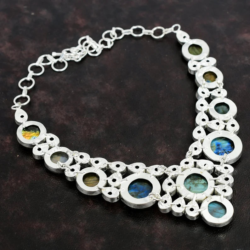 Silver necklace with circular pendants on a dark background