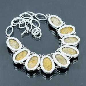 Bracelet with stone-enclosed links on a dark background