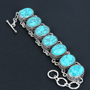 Turquoise stone bracelet with silver chain on a dark background