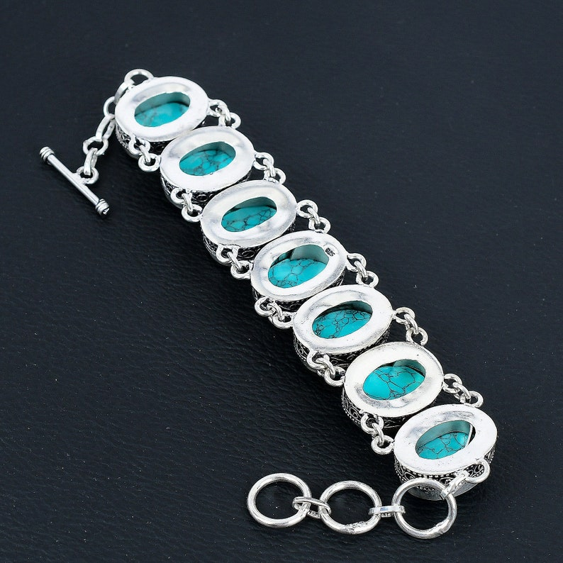 Silver bracelet with turquoise stones on a black background