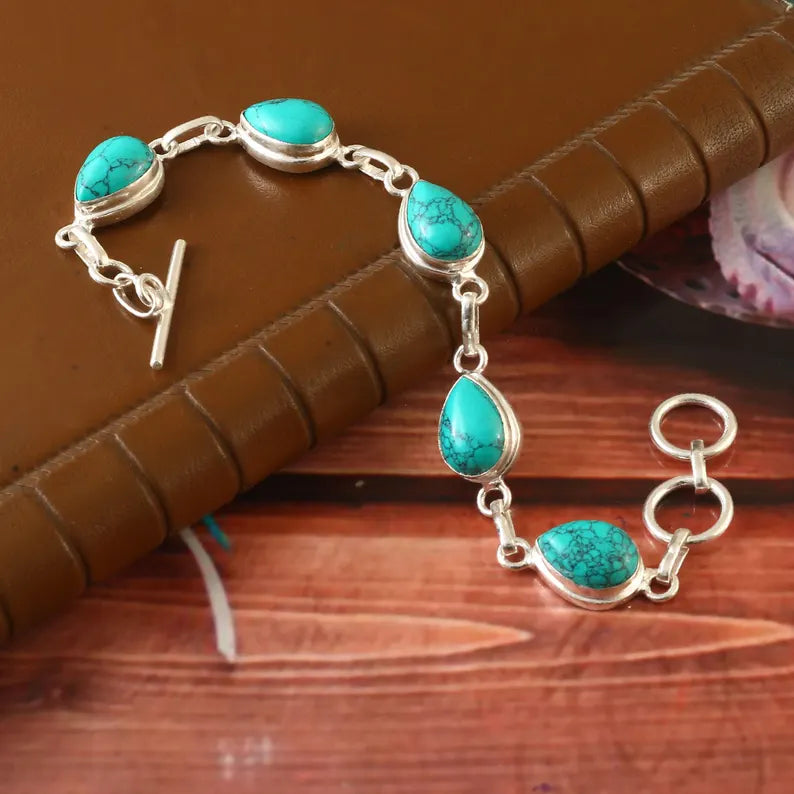 Silver bracelet with turquoise stones on a wooden surface