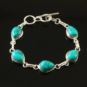 Turquoise bracelet with silver links on a black background