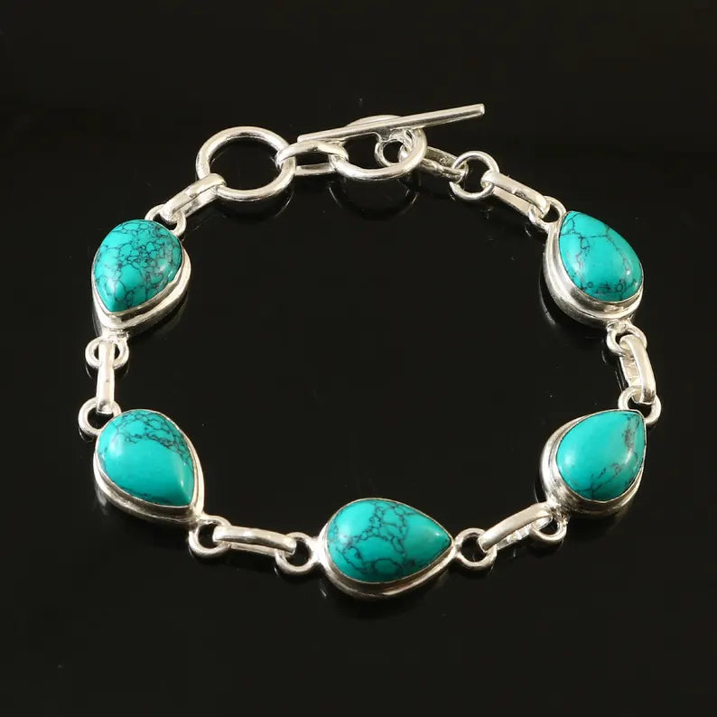 Turquoise bracelet with silver links on a black background