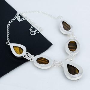 Silver necklace with tiger's eye stones on a black and white background