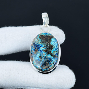 Blue and brown stone pendant on a silver chain against a black background